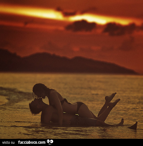 Bacio sdraiati in acqua al tramonto