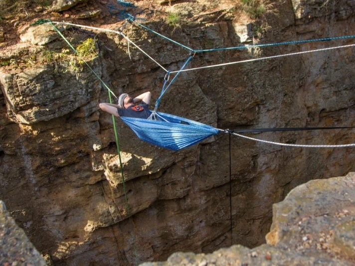 Uomo in branda sospesa su un canyon