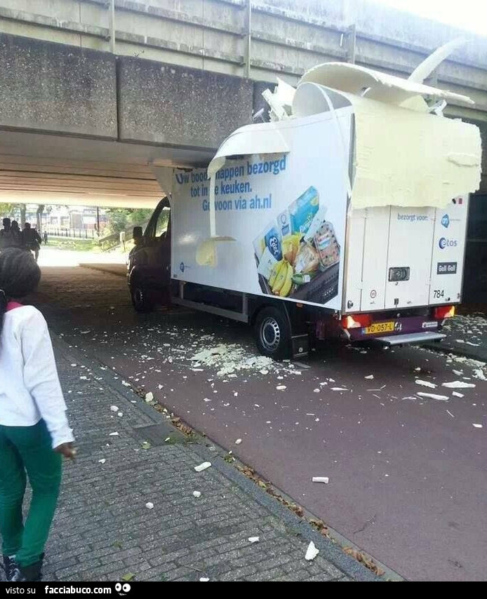 Camion con tetto sfondato sotto un cavalcavia