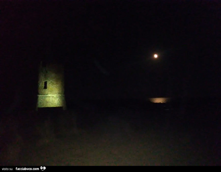 Luna illumina il faro sul mare