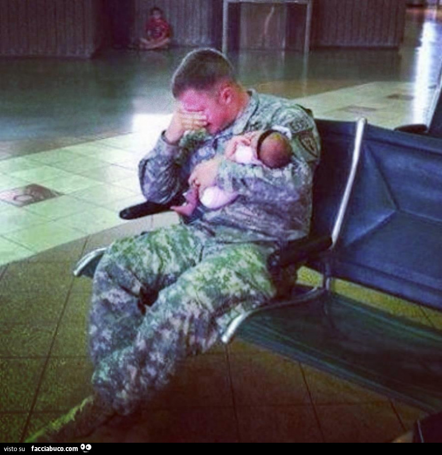 Militare che piange con il neonato in braccio