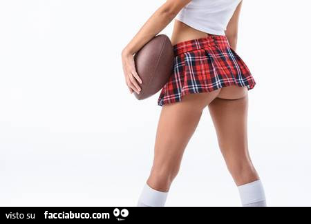 Ragazza con minigonna sexy e palla da rugby Facciabuco